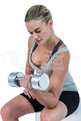 Muscular woman working out with dumbbells