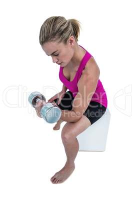 Muscular woman exercising with dumbbells