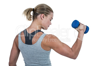 Muscular woman working out with dumbbells