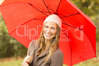 Smiling young woman under umbrella