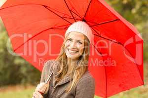 Smiling young woman under umbrella