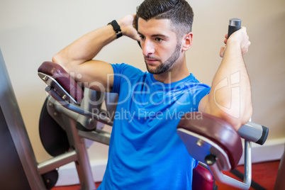 Concentrating man using weights machine