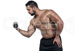 Muscular man lifting heavy dumbbell