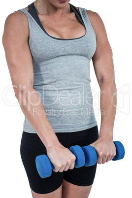 Muscular woman working out with dumbbells