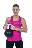 Muscular woman exercising with kettlebell