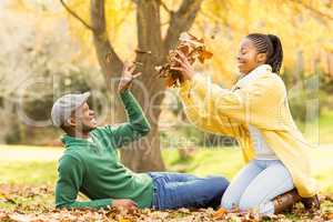 View of a young smiling couple in leaves