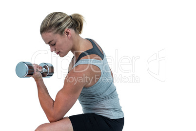 Muscular woman working out with dumbbells