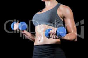 Muscular woman lifting heavy dumbbells