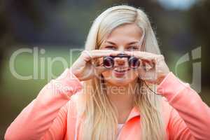 Happy blonde looking through binoculars