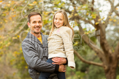 Happy father and his daughter posing in park