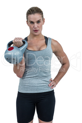 Serious muscular woman lifting kettlebell