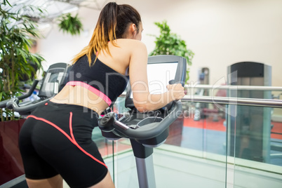 Woman on an exercise bike looking at the tv screen