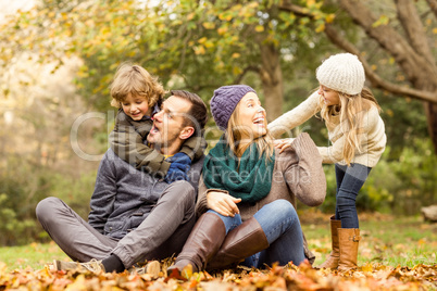 Smiling young family sitting in leaves