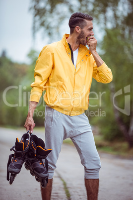 Handsome man holding inline skates