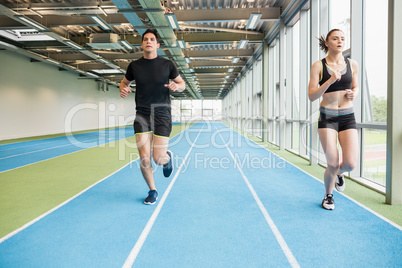 Couple running on the indoor track