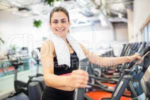Smiling woman on the cross trainer
