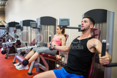 Focused man working out on the weights machine