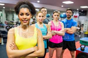 Fit people smiling at camera in weights room