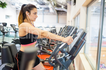 Focused woman on the ellipitical machine