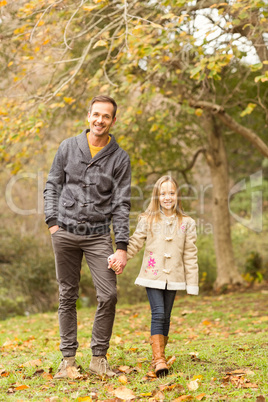 Happy father and daughter walking together in park