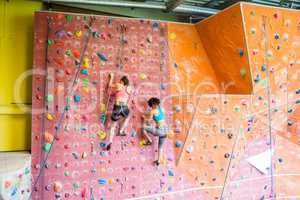 Fit women rock climbing indoors