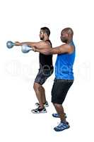 Strong friends lifting kettlebells together