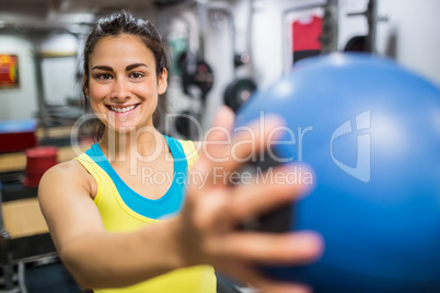 Smiling woman holding a medicine ball