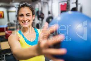Smiling woman holding a medicine ball