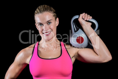 Muscular woman lifting heavy kettlebell