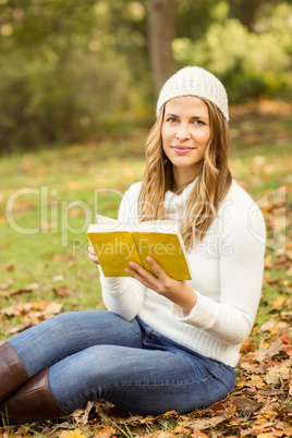 Portrait of a smiling pretty woman reading a book