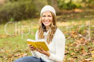 Portrait of a smiling pretty woman reading a book