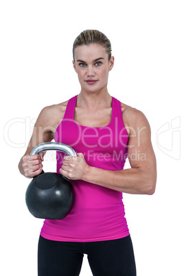 Muscular woman exercising with kettlebell