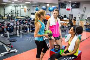 Fit women chatting in weights room