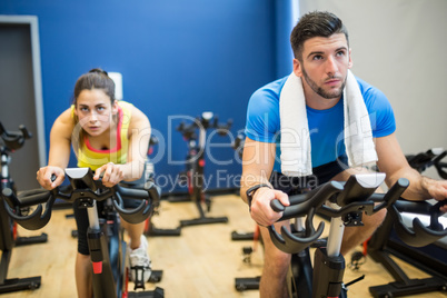 Focused couple using exercise bikes