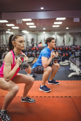 Fit couple working out in weights room