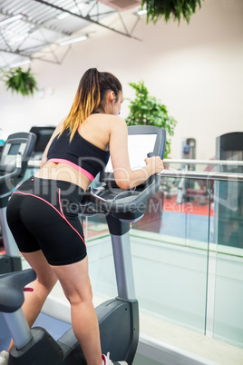 Woman on an exercise bike looking at the tv screen