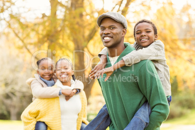 Portrait of a young smiling family in piggyback