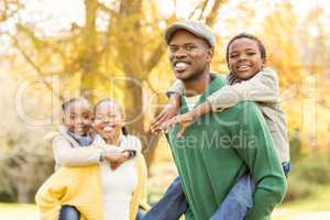 Portrait of a young smiling family in piggyback