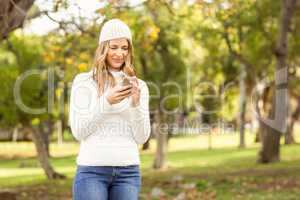 Smiling pretty woman texting with her smartphone