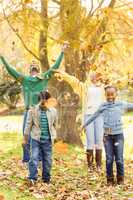 Young smiling family throwing leaves around