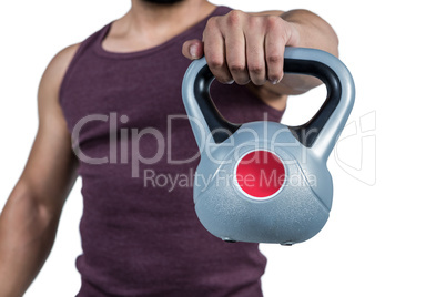 Mid section of a muscular man holding a kettlebell