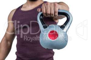 Mid section of a muscular man holding a kettlebell