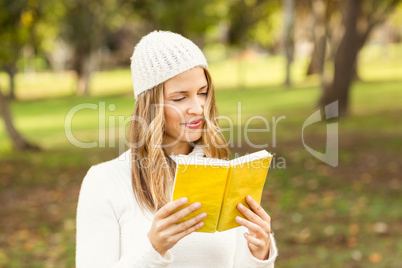 Smiling pretty woman reading a book