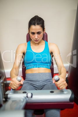Woman using weights machine