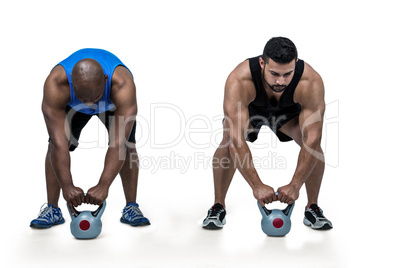 Strong friends lifting kettlebells together