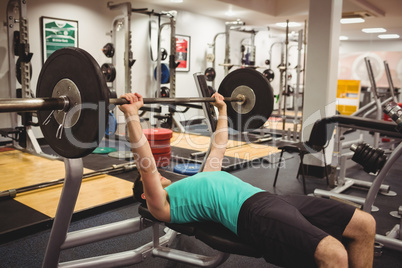 Fit man lifting heavy barbell