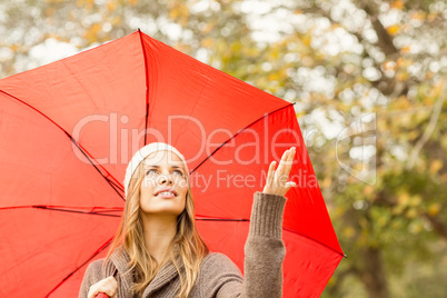 Woman under umbrella with hand raised