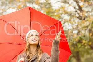 Woman under umbrella with hand raised