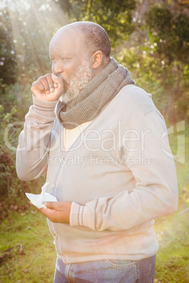 Senior man coughing with tissue