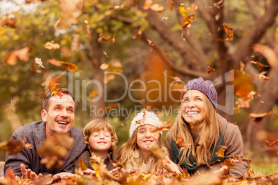 Smiling young family throwing leaves around